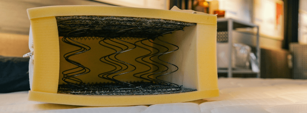 Cross section of a spring mattress surrounded with foam showing signs of yellowing